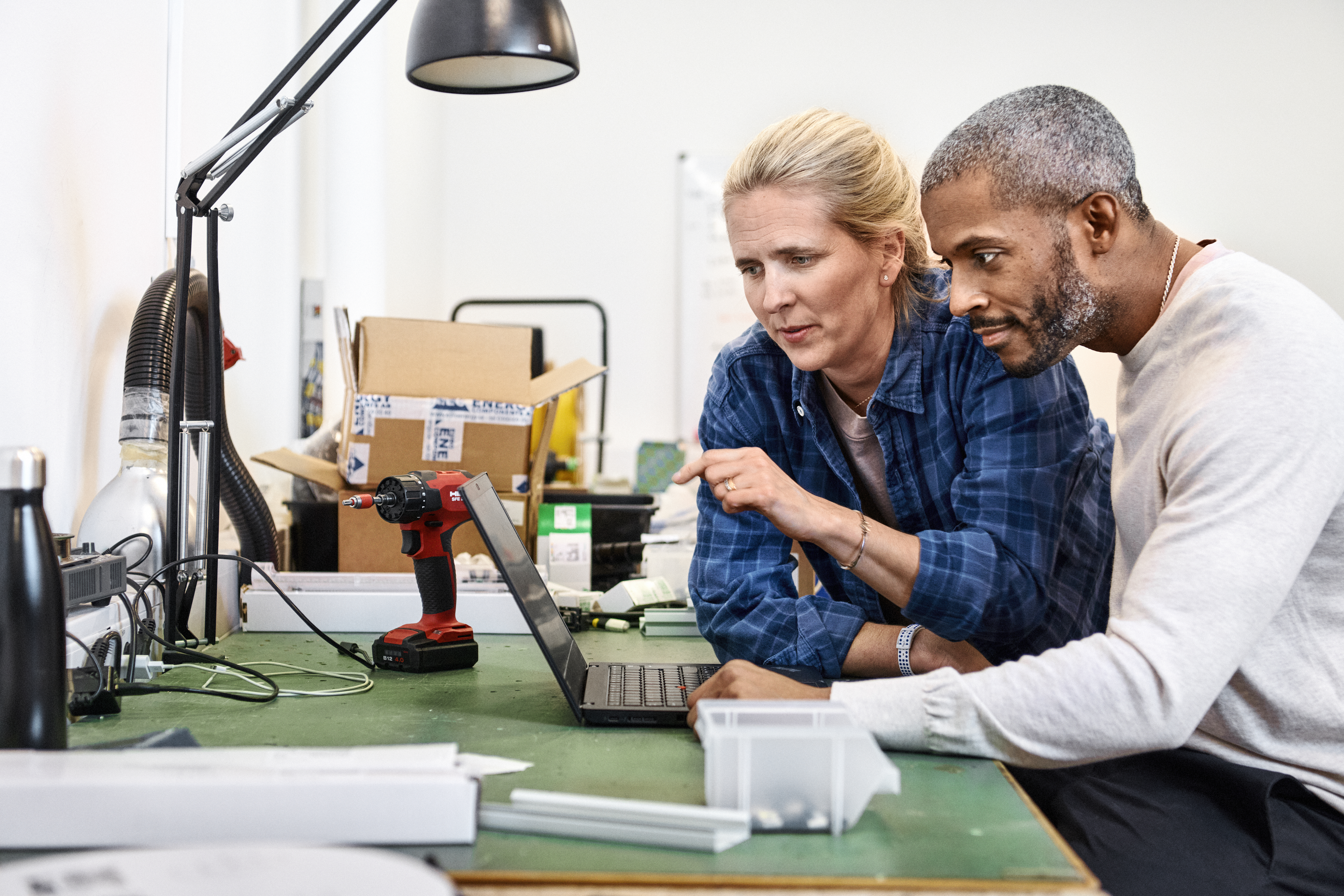 Kvinna och man vid ett skrivbord med en laptop.