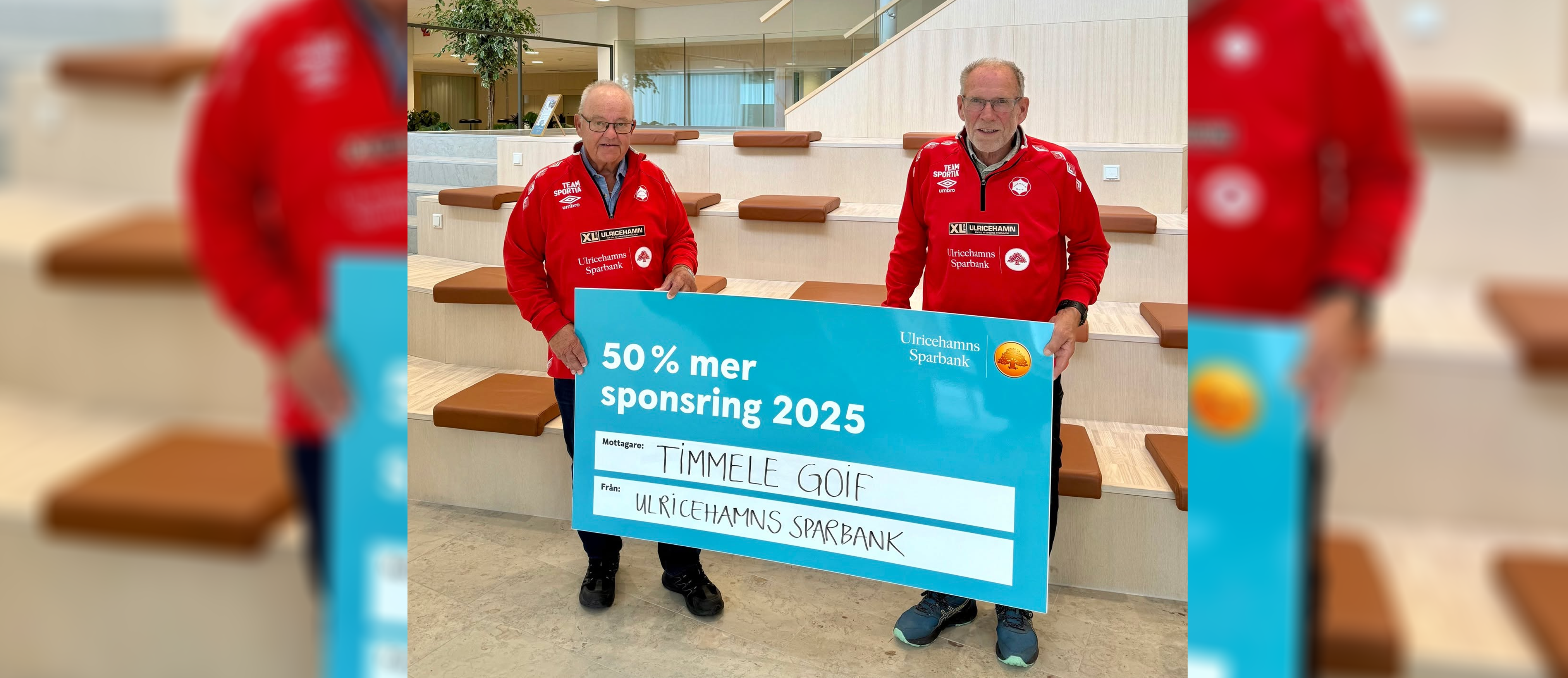 Två män iklädda röda föreningströjor står och håller upp en stor skylt där det står 50 % mer sonsring