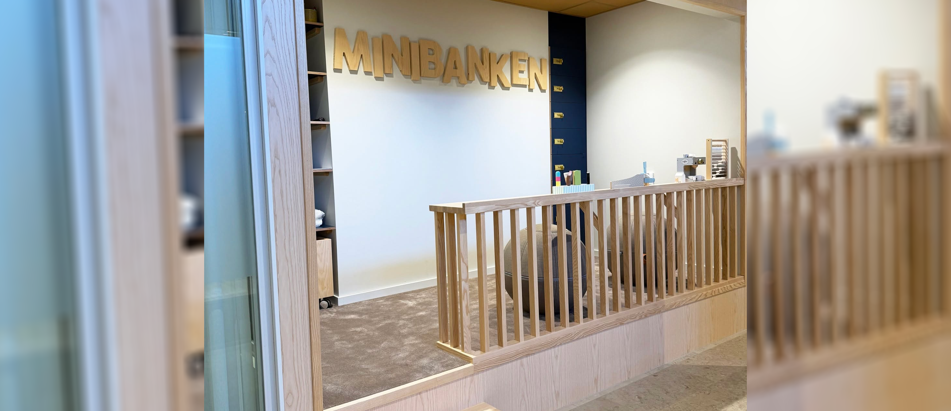 Ett litet utrymme med helteckningsmatta och staket med leksaker och leksaksbankfack