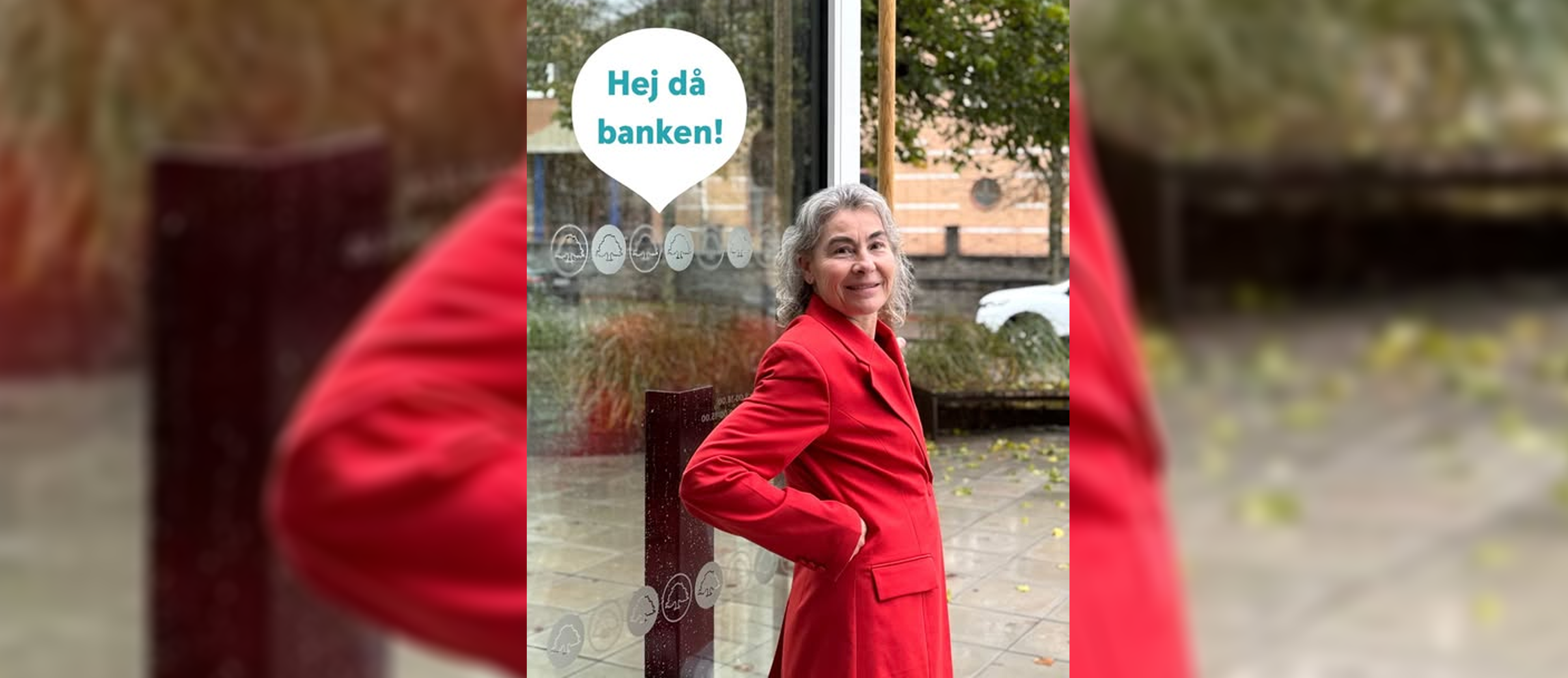 Kvinna i röd kavaj står redo att gå ut genom en entré