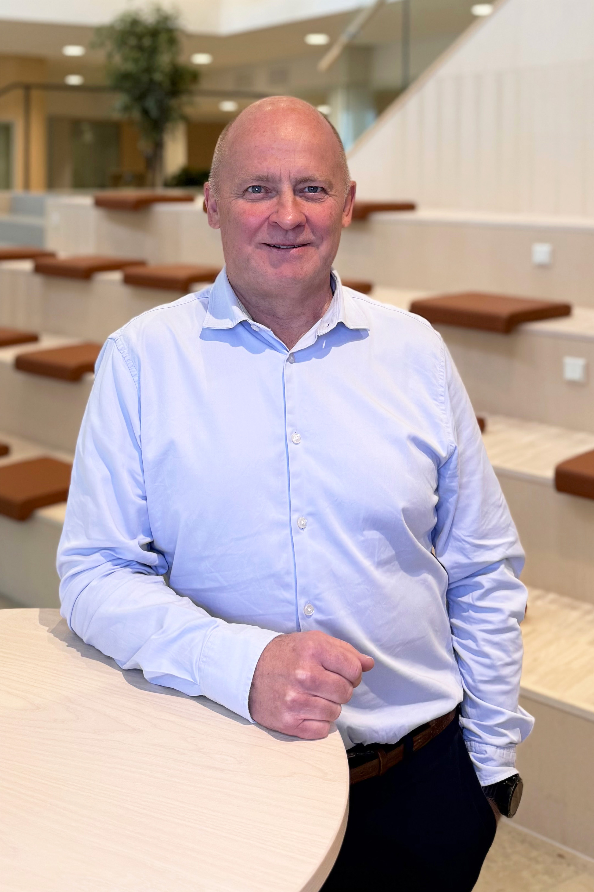 Man tittar in i kameran och ler